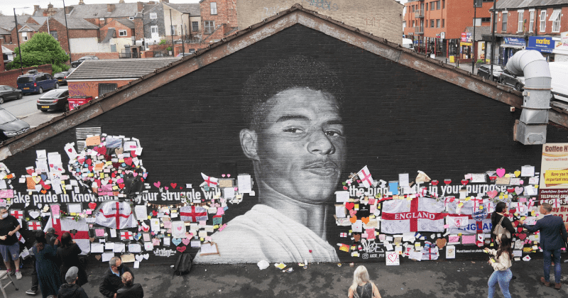 Love trumps hate: Locals cover racist graffiti on Black soccer star's mural with messages of love