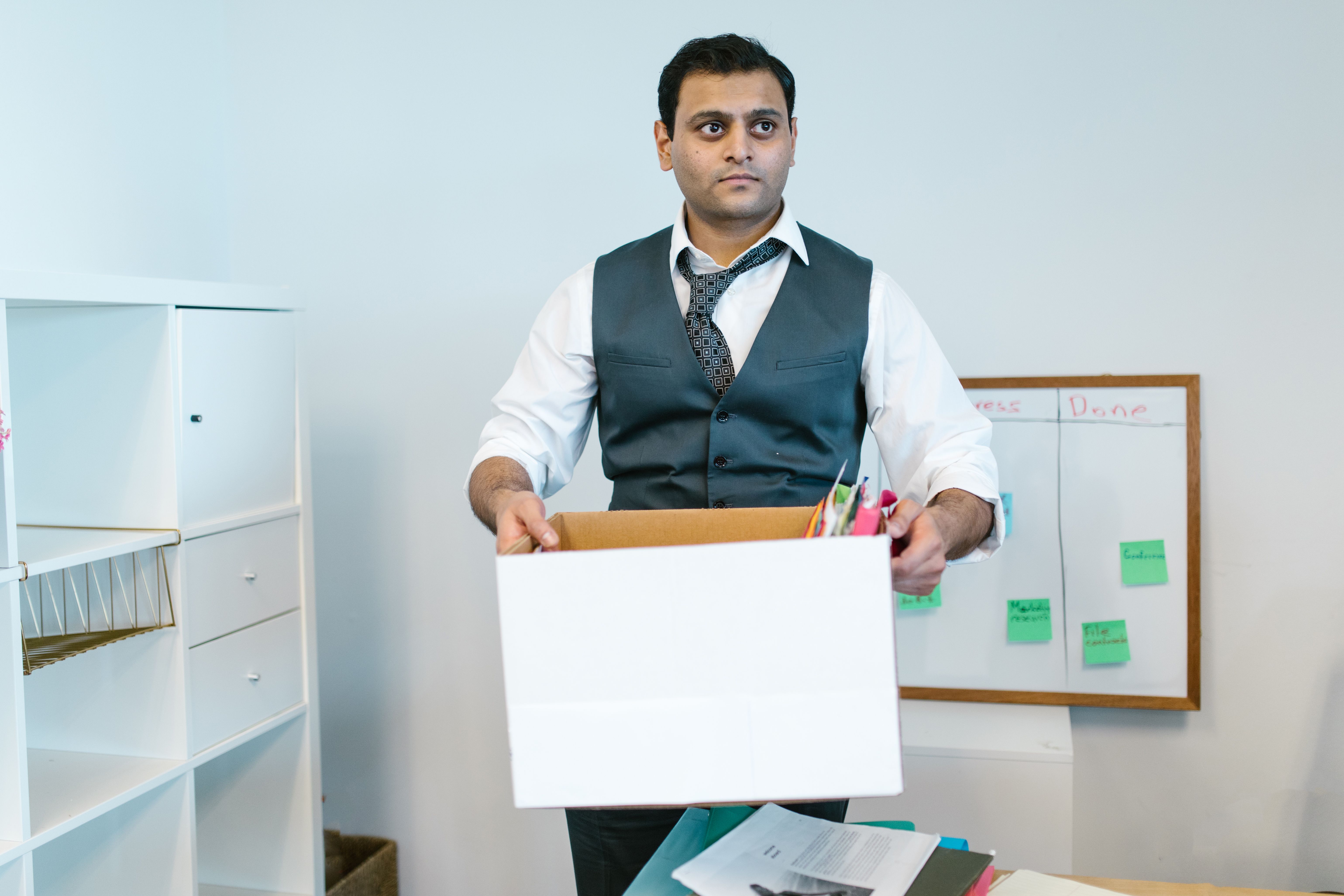 A man is holding his office belongings. (Representative Image Source: Pexels | Photo by RDNE Stock project)