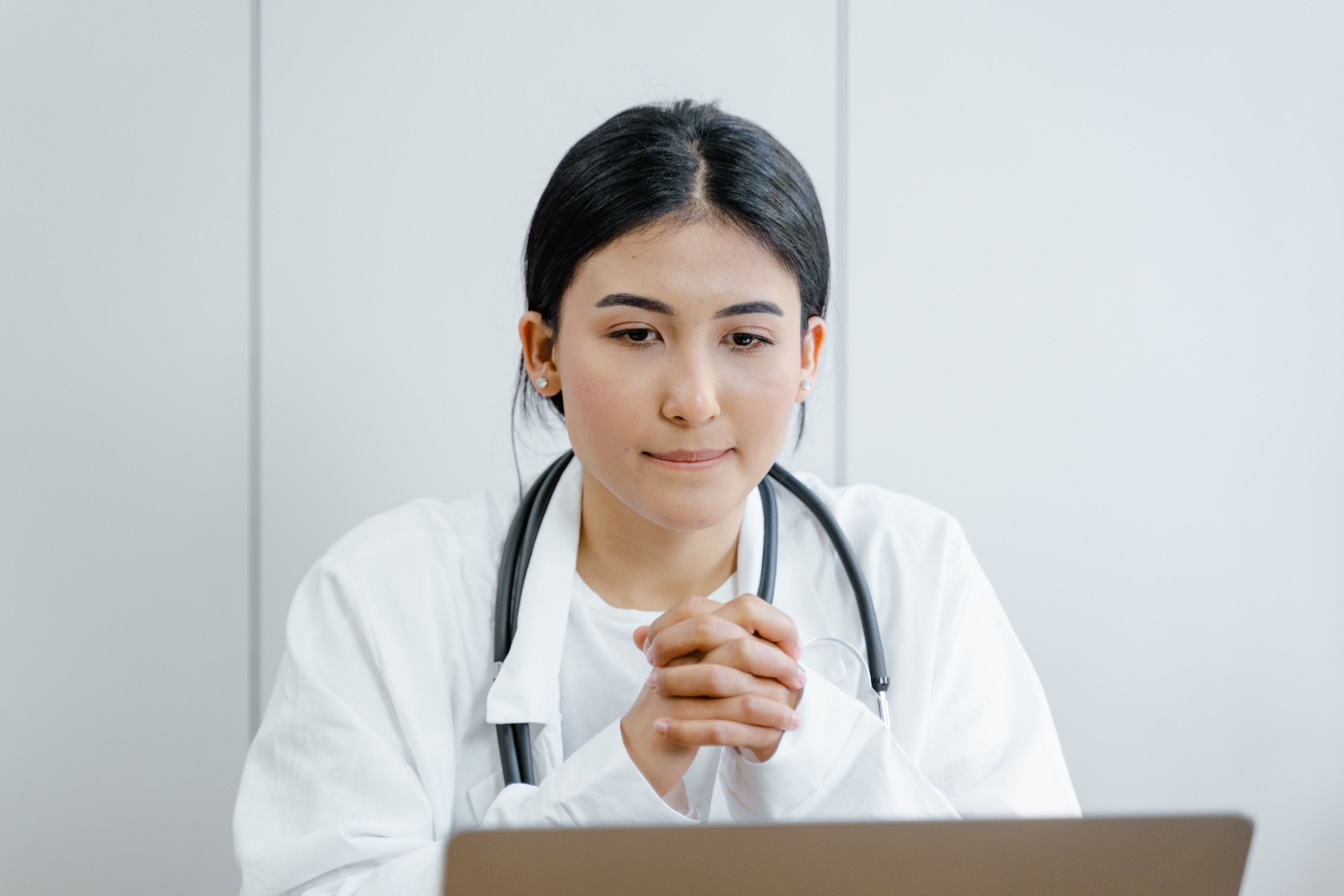 A nurse looks stressed, sitting with folded hands. (Representative Image Source: Pexels | Photo by Tima Miroshnichenko)