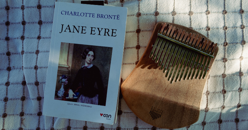A serene flat lay of Jane Eyre book and kalimba on a textured blanket (Representative Image Source: Pexels | Photo by Fukran Elveren)