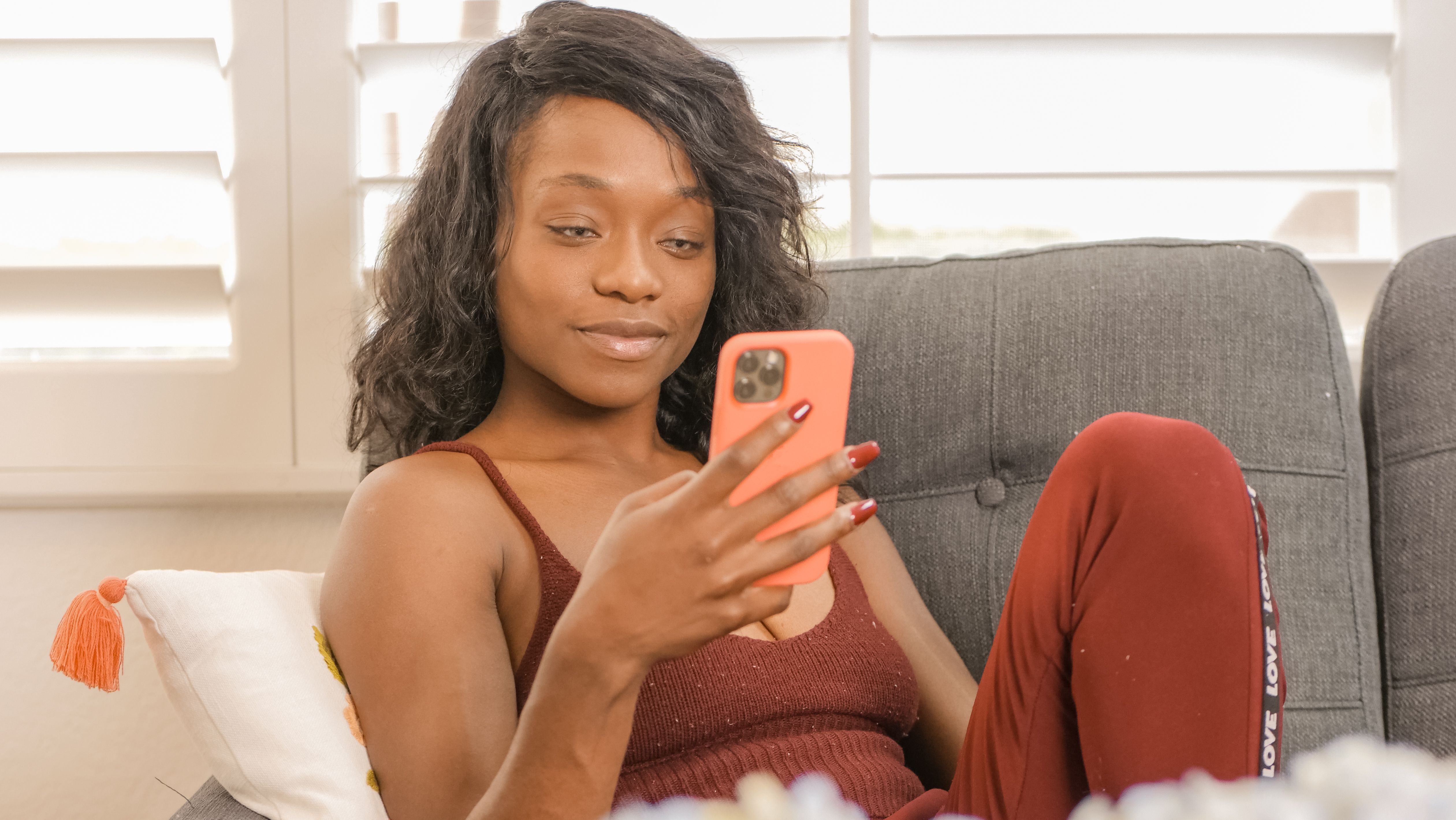 A woman is sitting on the couch, texting. (Representative Image Source: Pexels | Photo by Kindel Media)