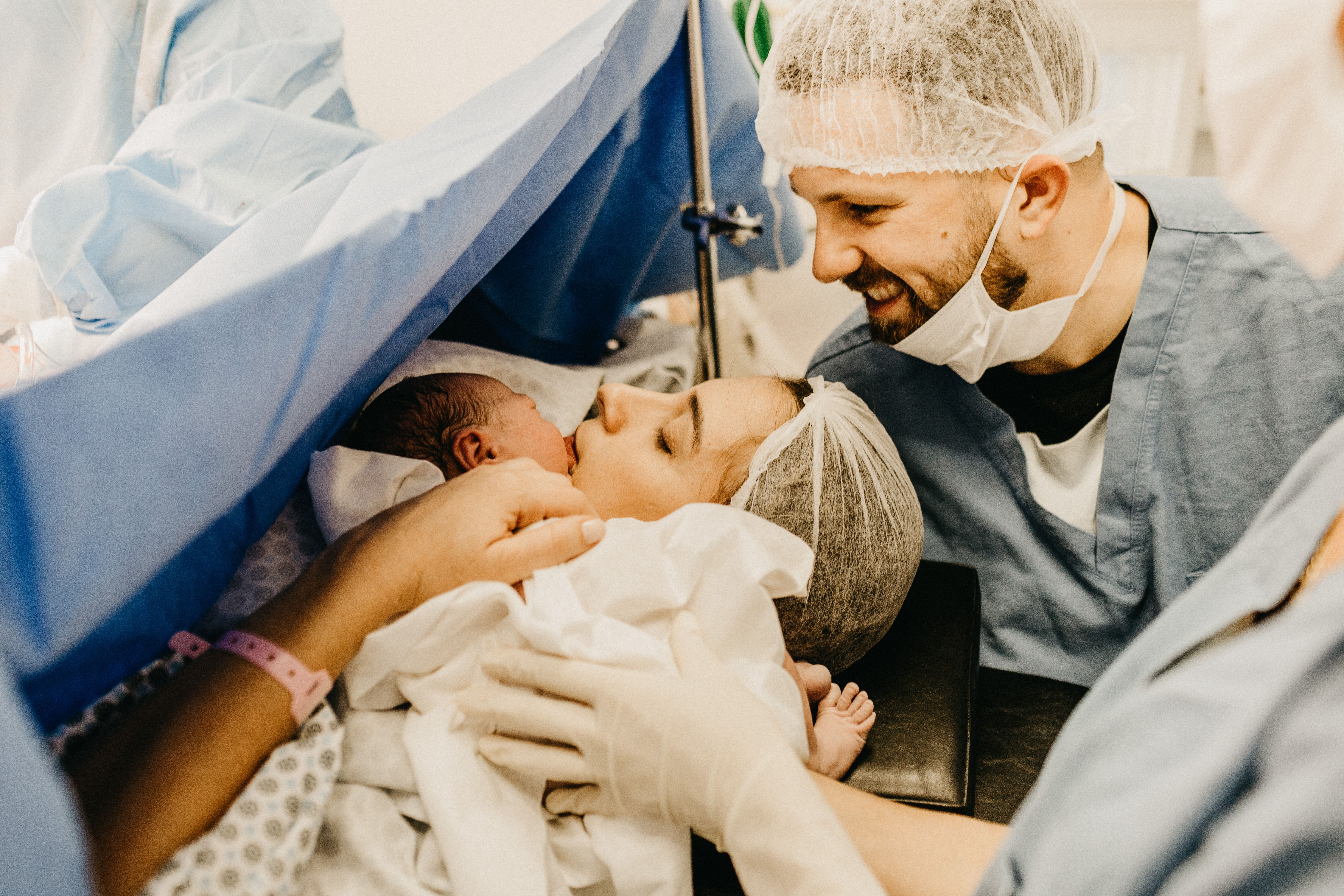 A cherished family moment as new parents welcome their baby in a hospital delivery room