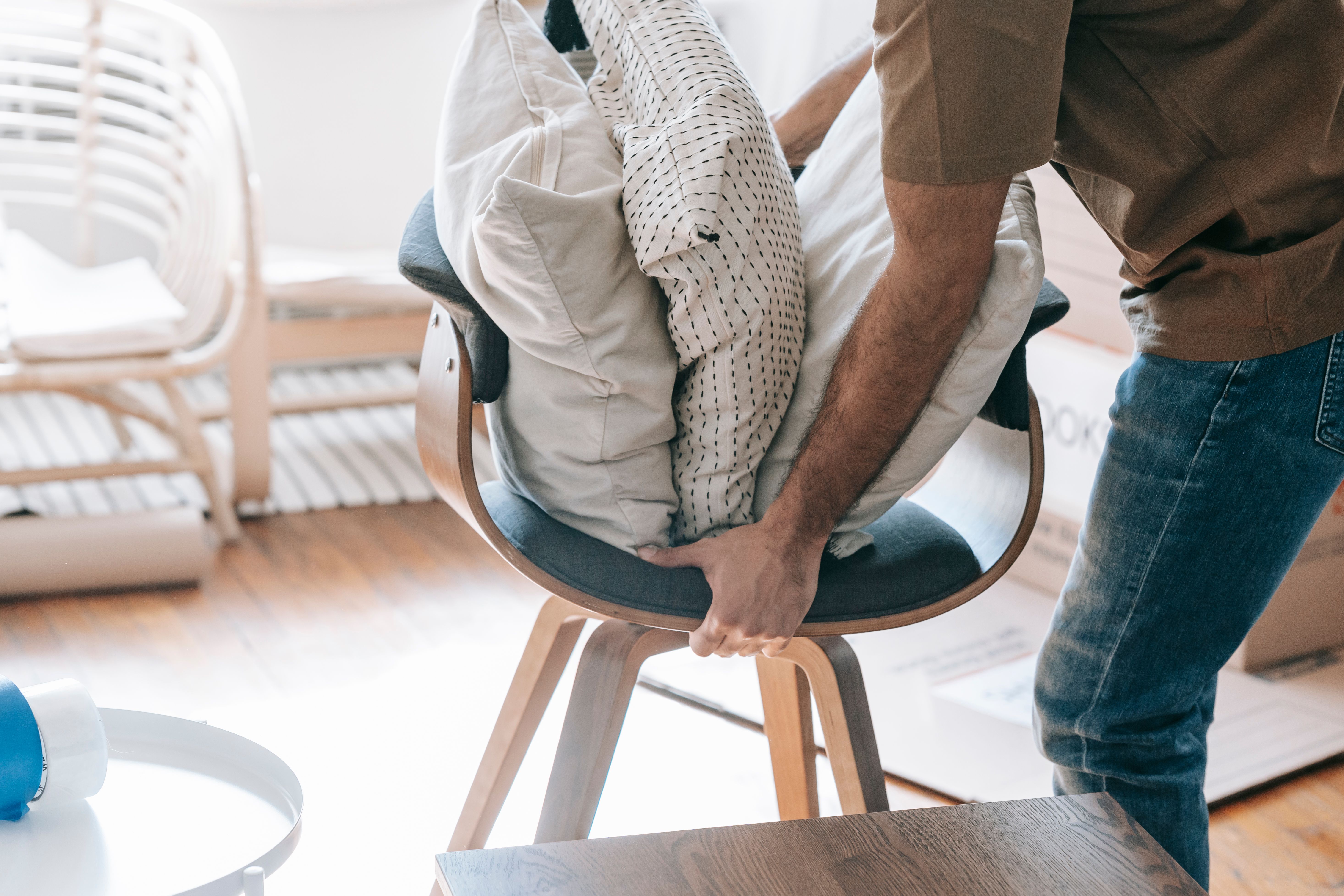A man carrying a wooden chair. (Representative Cover Image Source: Pexels | Photo by Blue Bird)