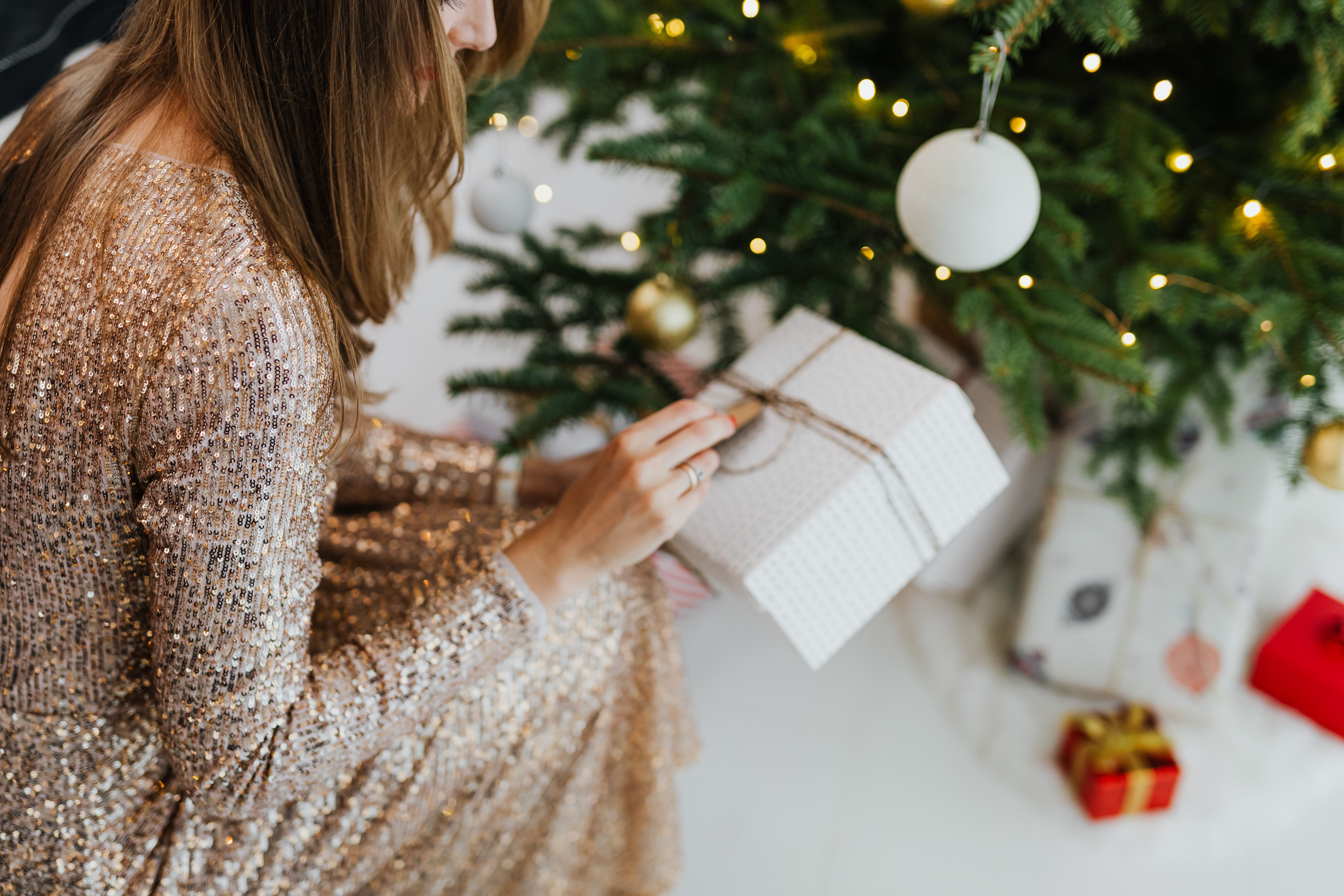 Woman opening a Christmas gift (Representative Image Source: Pexels | Photo by )