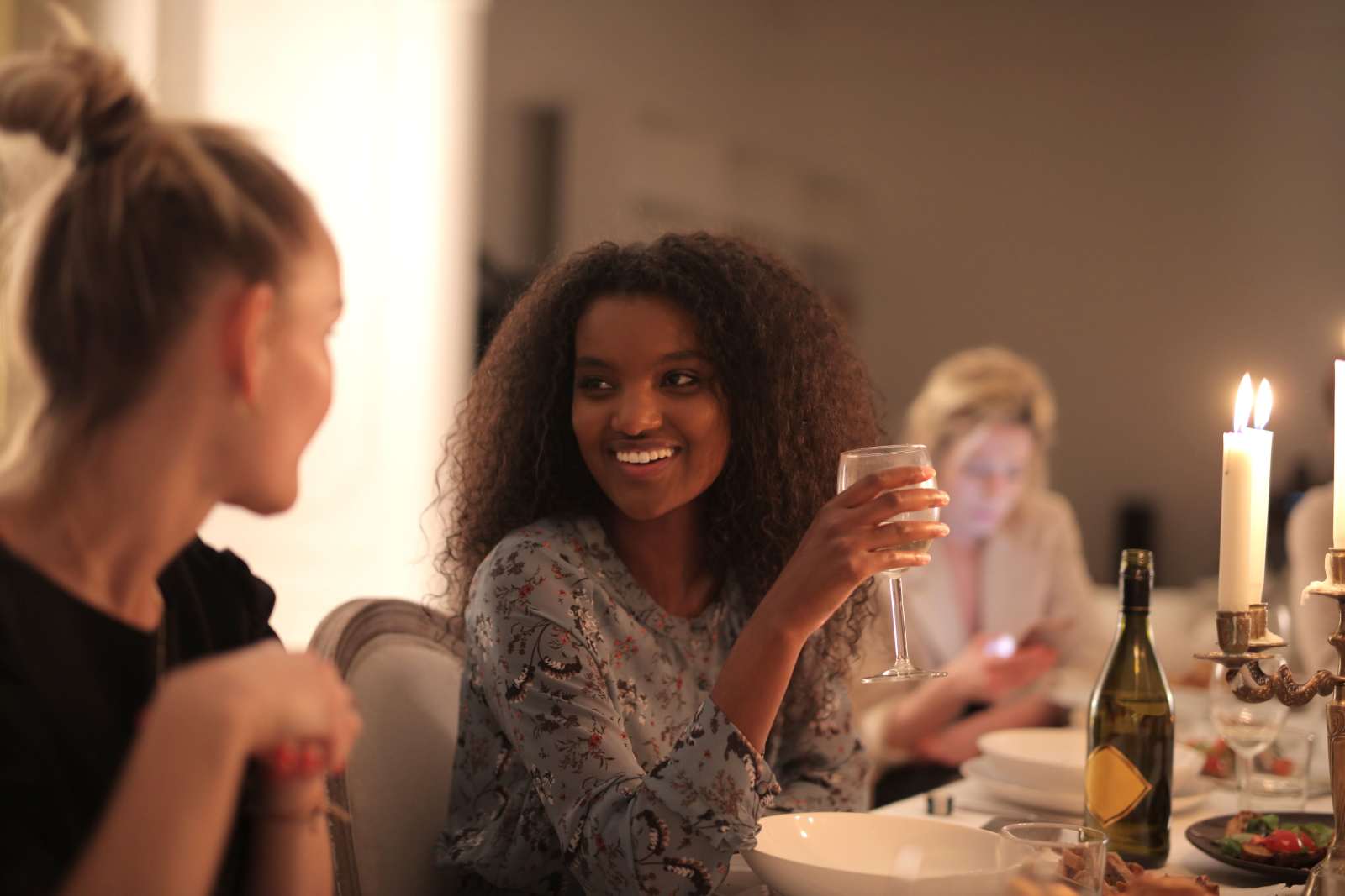 Happy friends enjoying a dinner party with wine and candlelight. (Representative Cover Image Source: Pexels | Photo by Andrea Piacquadio)