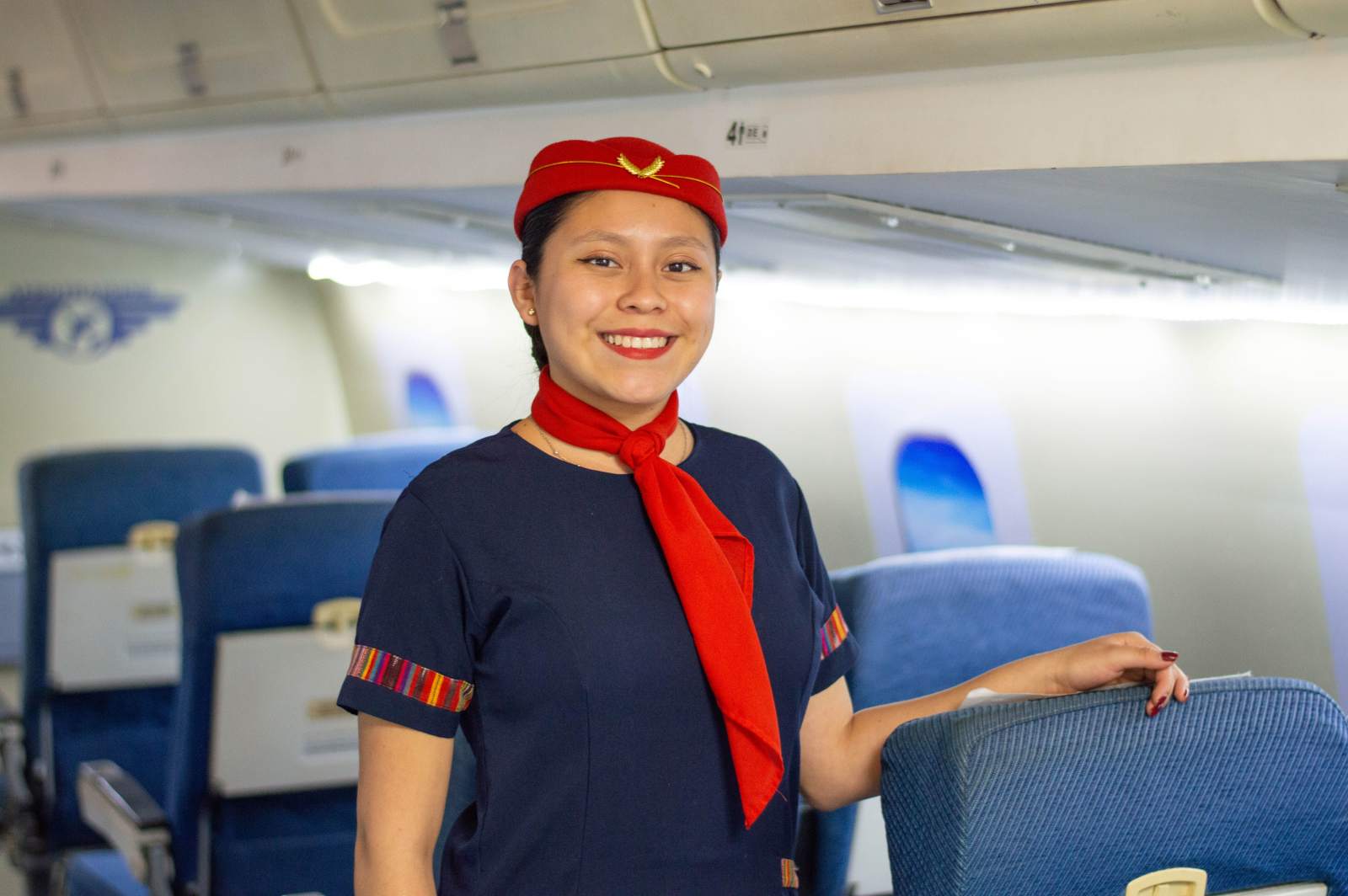Smiling flight attendant poses inside the plane (Representative Image Source: Pexels | Photo by )