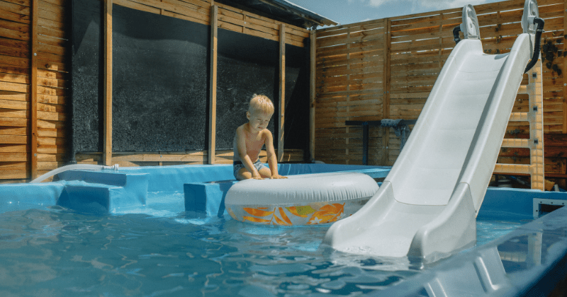 Young child playing with inflatable in a pool with slide during summer (Representative Image Source: Pexels | Photo by Helena Jankovičová Kováčová)