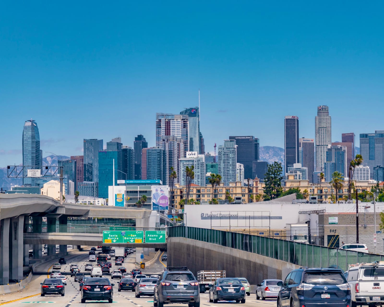 Downtown Los Angeles skyline with busy freeway traffic on a sunny day