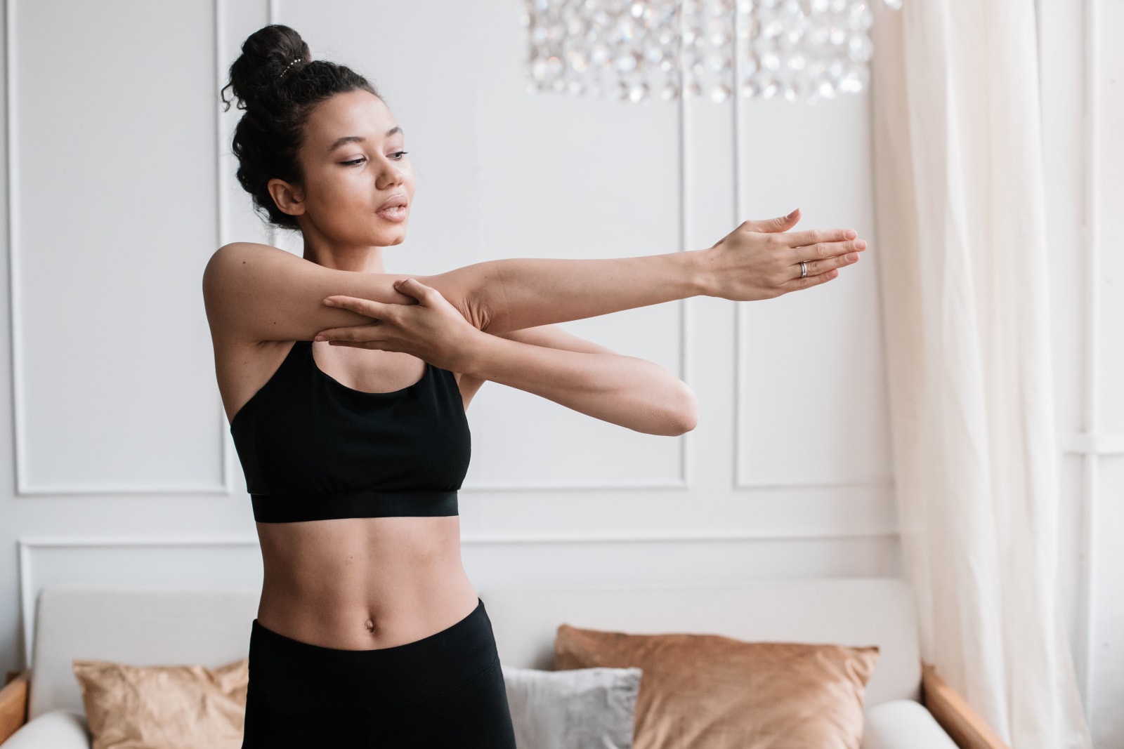 A young woman in activewear stretches indoors, embodying a healthy lifestyle. (Representative Image Source: Pexels | Photo by Pavel Danilyuk)