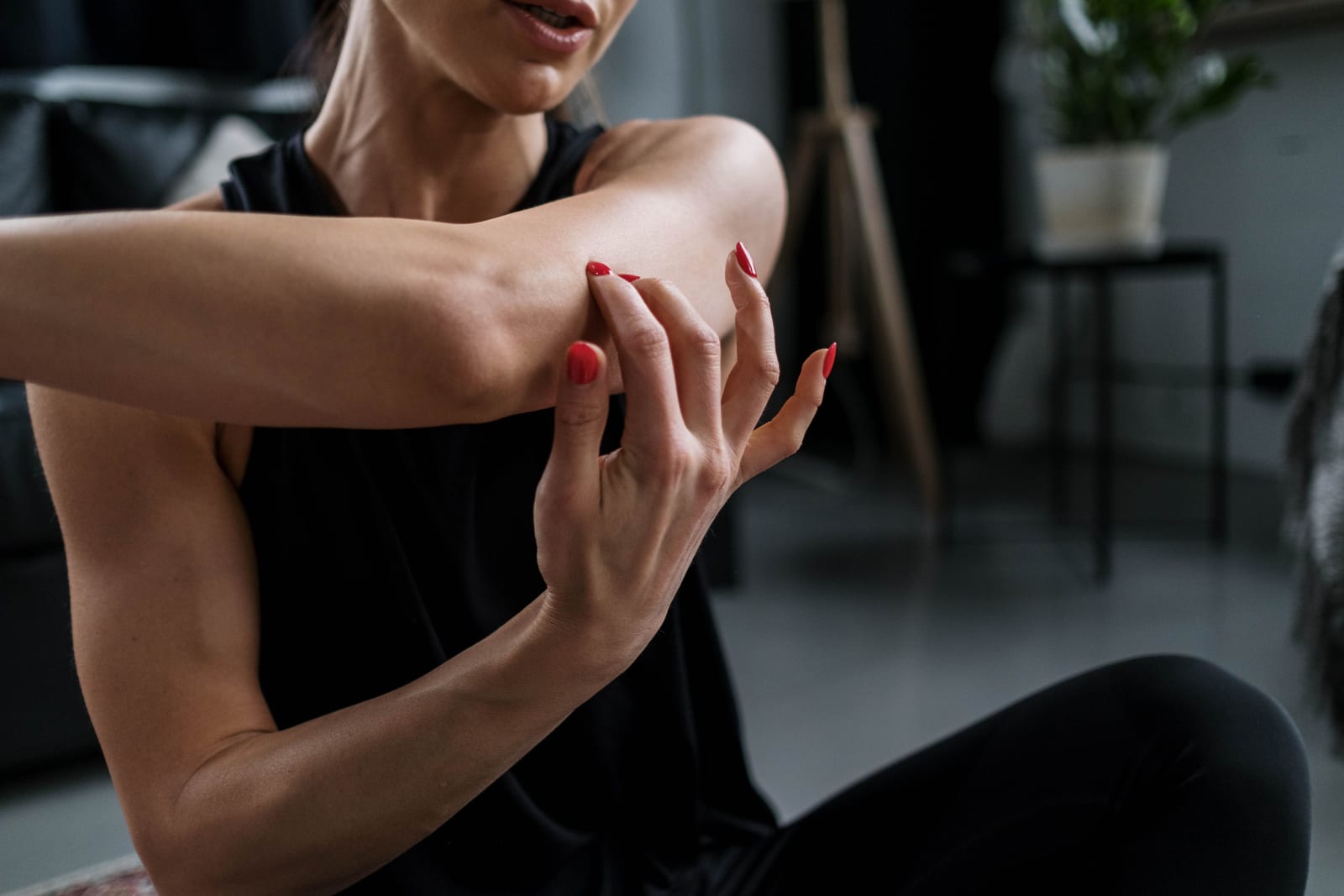 Woman stretching arm during home workout for wellness and flexibility.