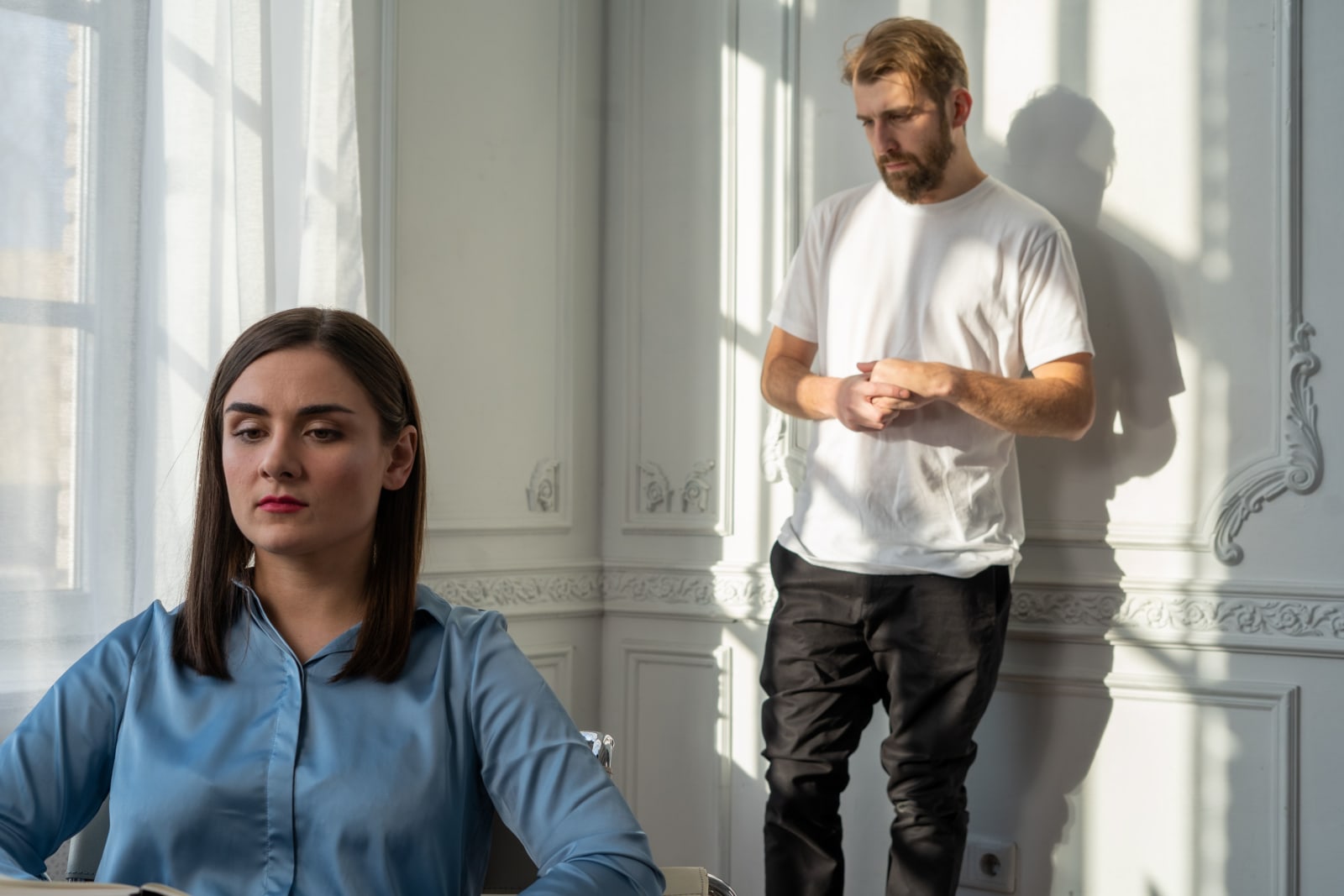 Man looking at his phone and woman feeling distressed (Representative Image Source: Pexels | Photo by )