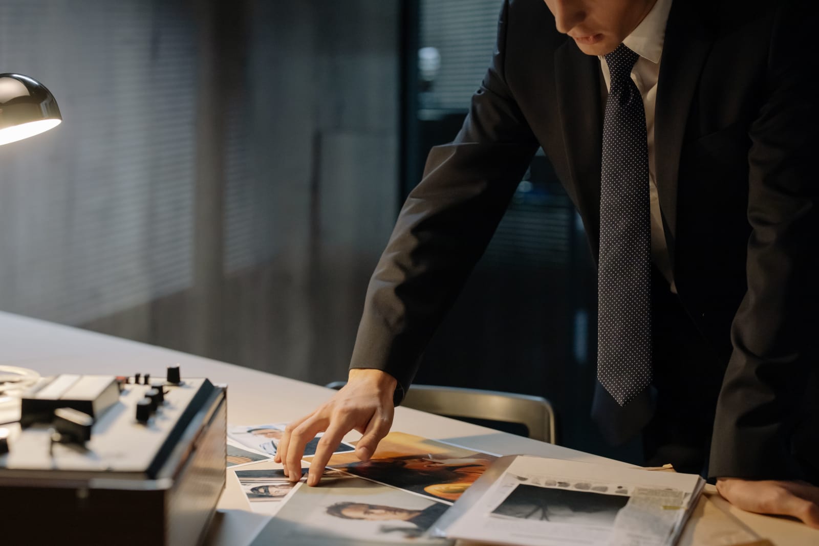 A man in a suit going through some photographs. (Representative Cover Image Source: Pexels | Photo by cottonbro studio)