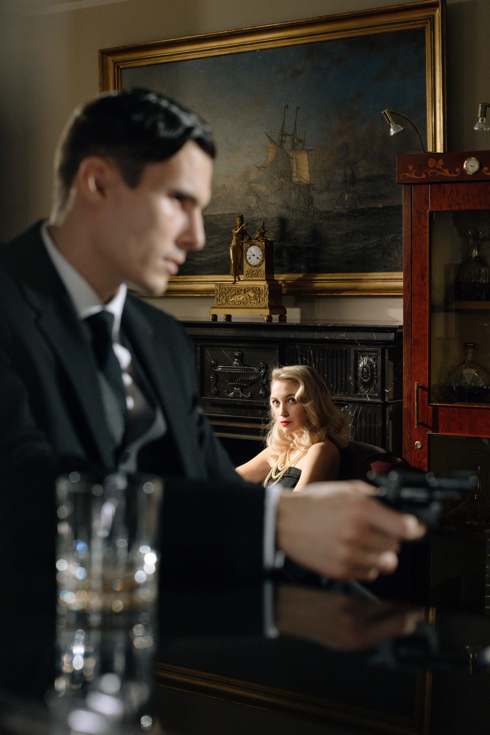 A dramatic noir setting featuring a mysterious man and a femme fatale in a vintage bar.