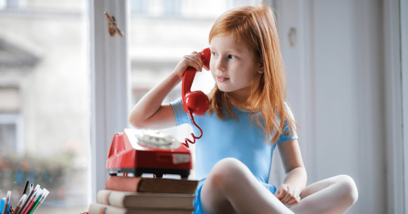 Adorable red-haired girl using a rotary phone (Representative Image Source: Pexels | Photo by Andrea Piacquadio)