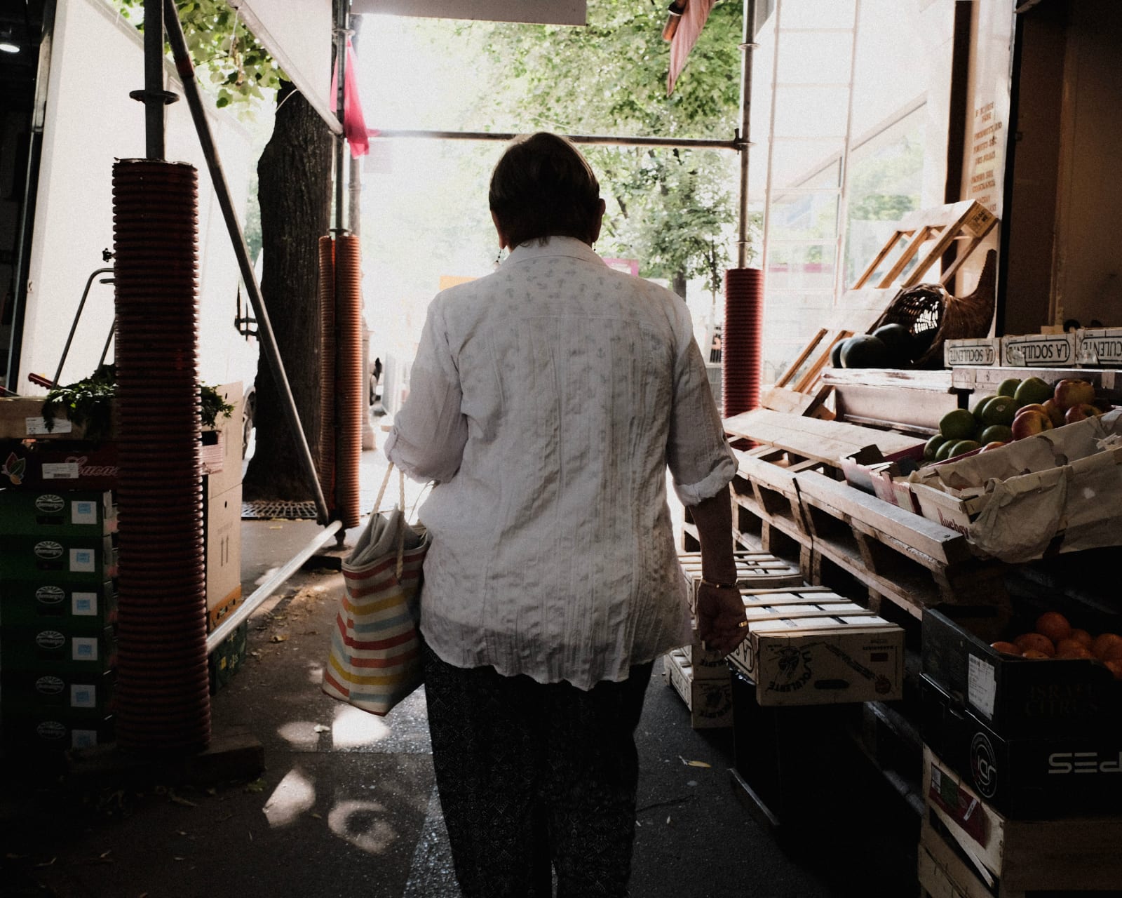 A woman with a bag walking through a vibrant open-air market during the day. (Representative Cover Image Source: Pexels | Photo by Mathias Reding)